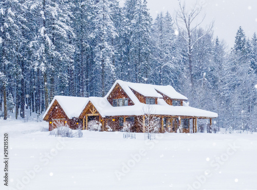 Rural country vacation house home in snowy winter  with lights on and snowing
