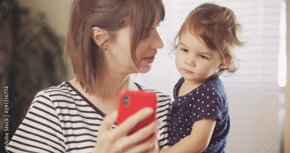 Happy Mother and Baby Girl Having Video Chat on Smartphone. Shot in 4K RAW on a cinema camera. Happy Mother and Baby Girl Having Video Chat on Smartphone. Shot in 4K RAW on a cinema camera.