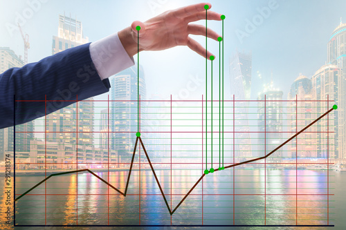 Businessman controlling the market with strings