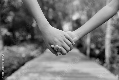 Two children holding hands each other on the wooden way and natural background in the morning. Friendship Day, Best Friend concept.