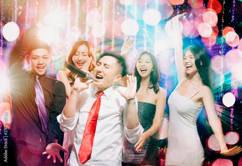happy young group singing and dancing in party