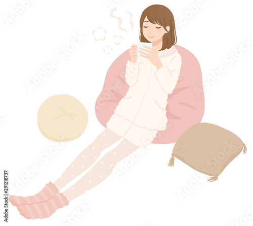暖かい部屋着で飲み物を飲む女性