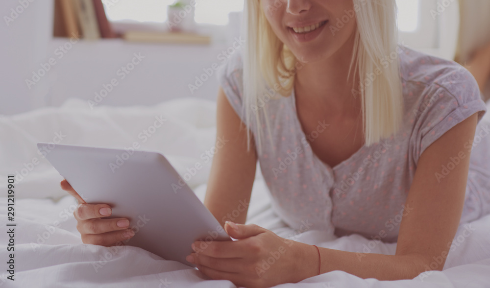 Girl holding digital tablet with blank screen and smiling at camera in bedroom Girl holding digital tablet with blank screen and smiling at camera in bedroom