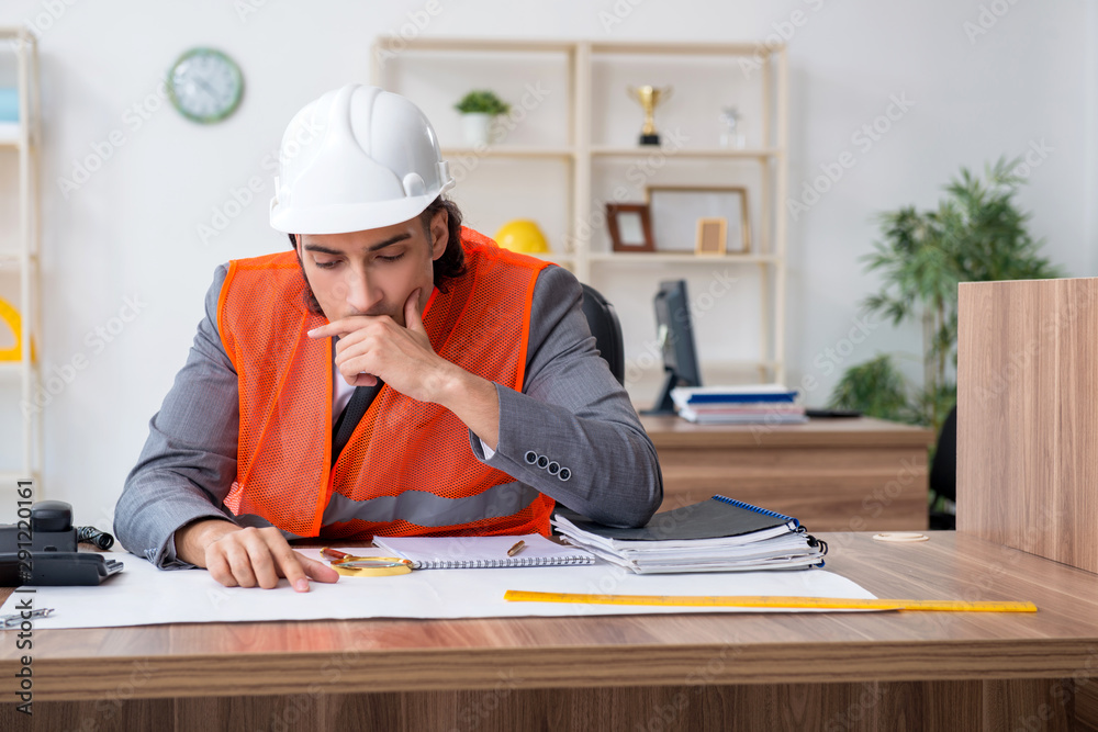 Young male architect working in the office Young male architect working in the office