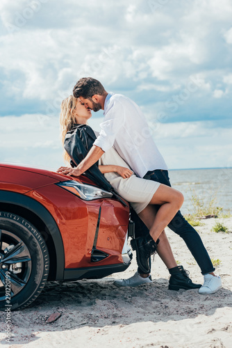 attractive woman and handsome man kissing on car outside © LIGHTFIELD STUDIOS