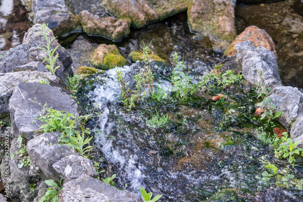 Renaturierter Fluss oder renaturierter Bach fließt mäandrierend durch Felsen mit Stromschnellen und Kehrwasser zur Freude der Tiere und Pflanzen in der Natur