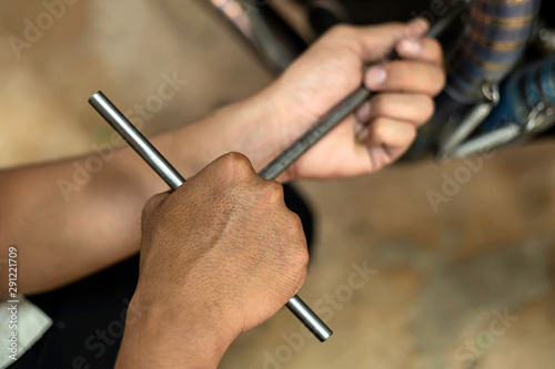 Image is Close up, Auto mechanic are repairing a motorcycle Use a wrench and a screwdriver to work.