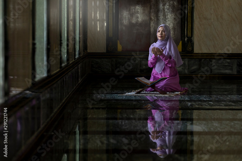 Muslim women wearing purple shirts Doing prayer According to the principles of Islam..