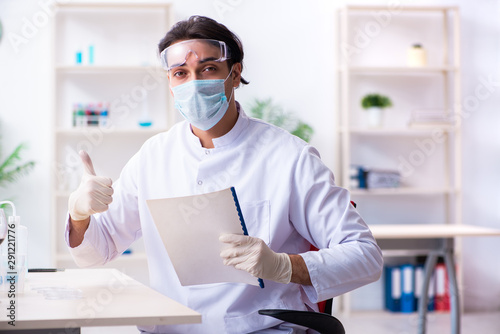 Male chemist examining wine samples at lab