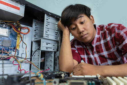 Wallpaper Mural Tired and bored computer repairman is sitting on his workplace and thinking. Torontodigital.ca