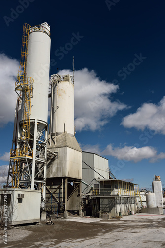 Portland cement plant with ground clinker silos with blue sky
