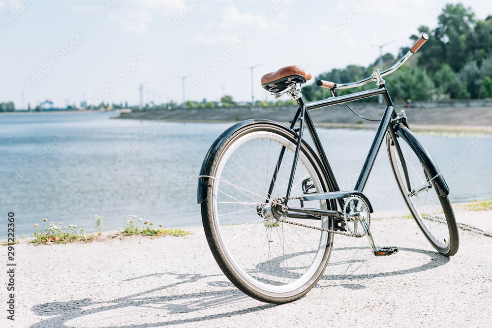 bicycle near blue river in summer in sunshine