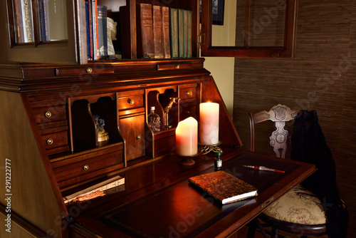 Fotografie Classic secretary writing desk in dark room with candles and chair
