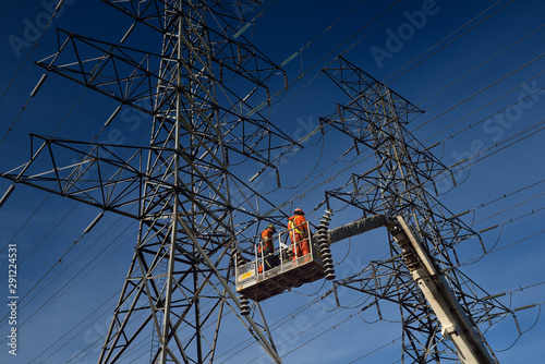 Photography Hydro linemen on boom lift removing old suspension insulators on high voltage po