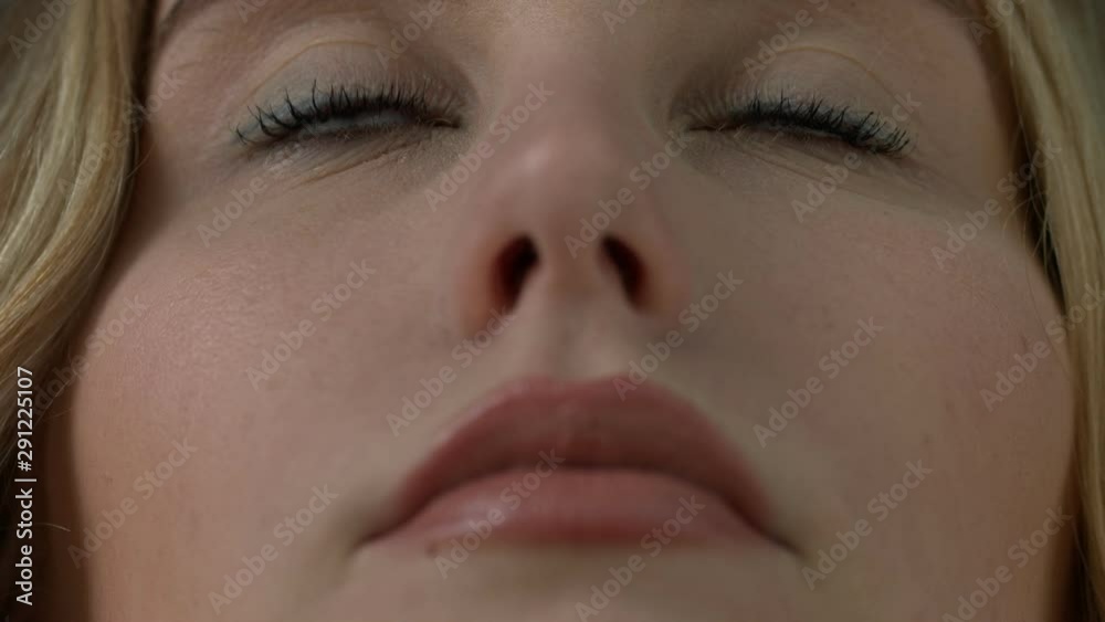 Close up beautiful portrait of blond female models face, focus on brown eyes, low angle slow motion static shot Close up beautiful portrait of blond female models face, focus on brown eyes, low angle slow motion static shot