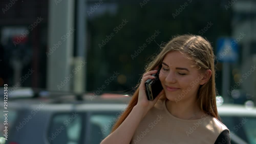 Pretty girl in urban environment talking on mobile phone, smiling and looking happy. Pretty girl in urban environment talking on mobile phone, smiling and looking happy.