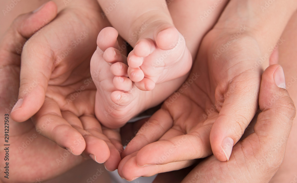Hands of father and mother hold baby feet. Family Hands of father and mother hold baby feet. Family