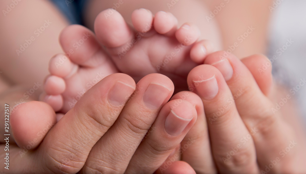 Mother's hands carefully keeping baby's foot Mother's hands carefully keeping baby's foot