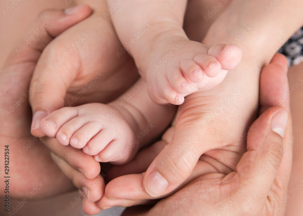 Hands of mother and father hold baby feet Hands of mother and father hold baby feet