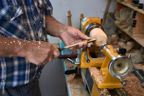The woodturner work. Man's arms with cutter in action.