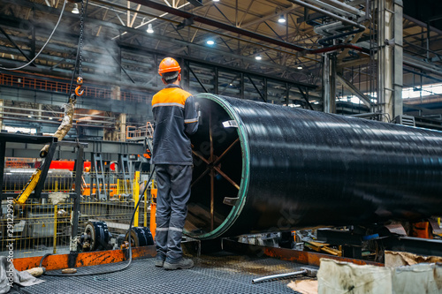 Papier peint Worker installs clamping ring on coated pipe