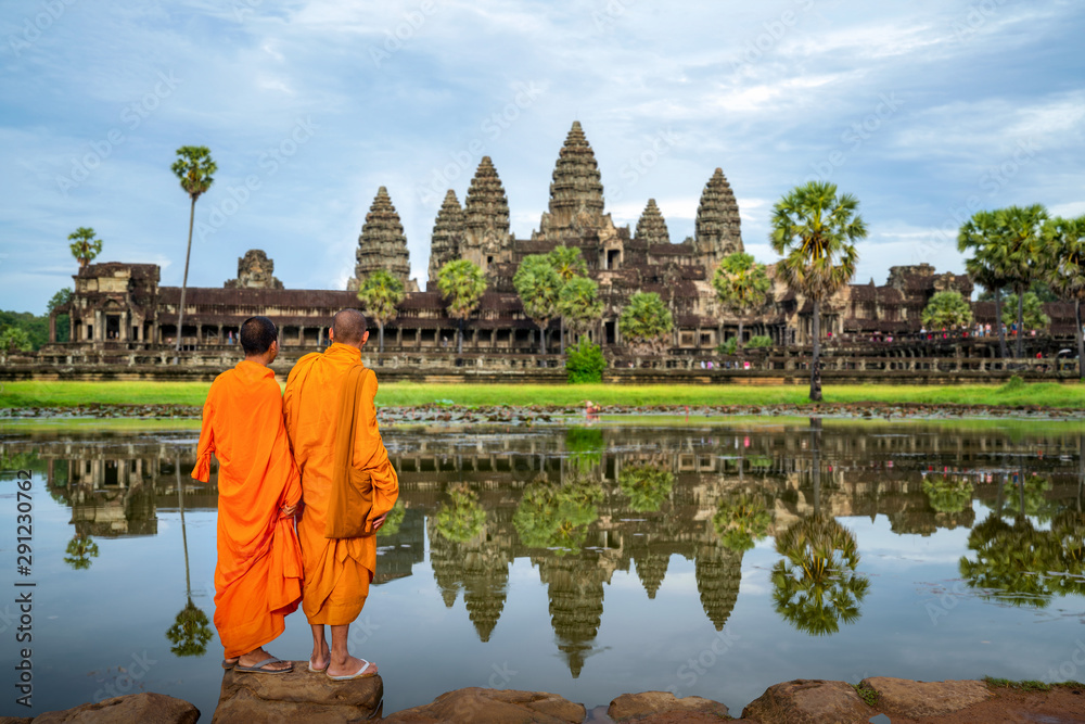 Naklejka premium Azjatycki mnich wstaje i patrzy na Angkor wat w siem reap