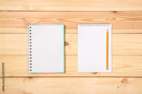 top view of a open notebook with pencil on a wooden background, school notebooks with a spiral spring, office notepad . Flat lay