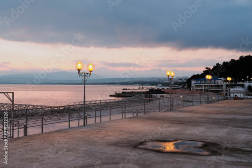 Sunset  lampposts on the background of the sea  promenade. Silence and the night sky.