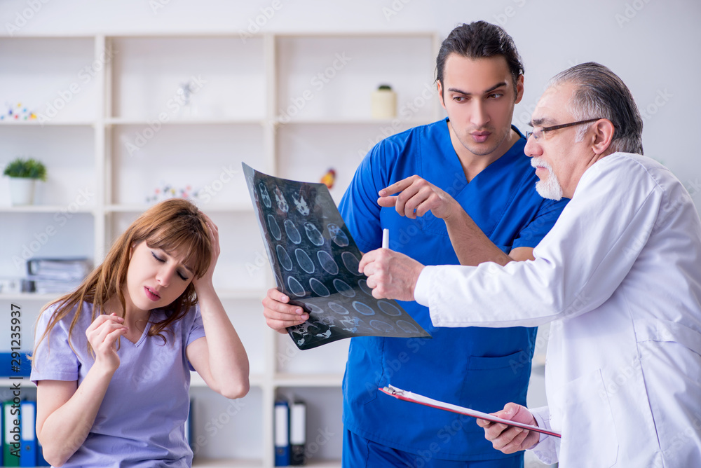 Fototapeta premium Two doctors examining young woman