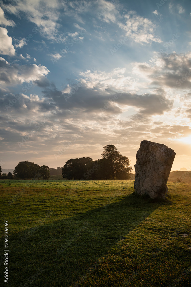 Stunning Summer sunrise landscape of Neolithic standing stones in English cluntryside with gorgeous light with slight background mist