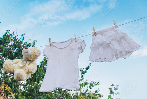 White clothes dry on a rope in the summer. Selective focus. photo