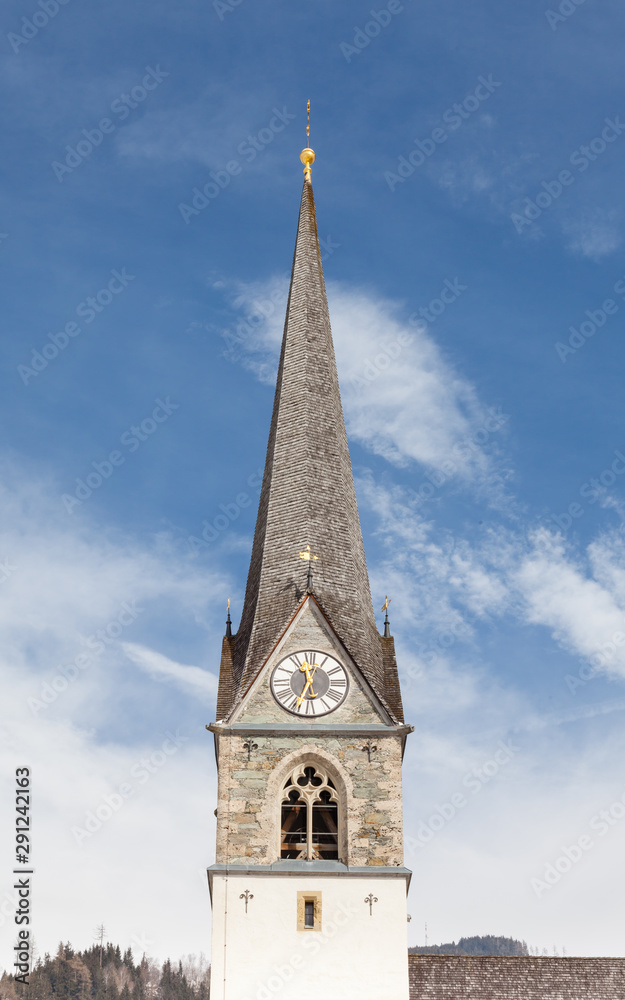 A close up of the bell tower of the Catholic parish church of Bruck an der Grossglocknerstrasse in the state of Salzburg, Austria.