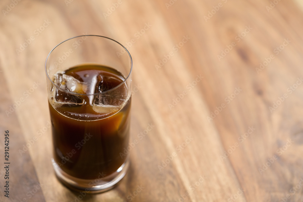 Glass of iced coffee on wooden table