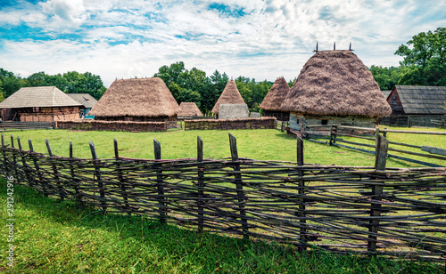 Stunning summer view of traditional romanian peasant houses. Bright rural scene of Transylvania, Romania, Europe. Beauty of countryside concept background. photo