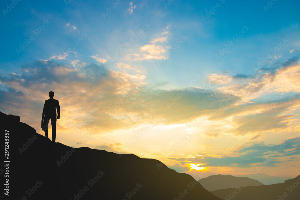 silhouette of man on mountain top over sky and sun light background,business, success, leadership, achievement and people concept