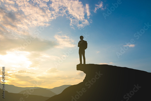 silhouette of backpacker on mountain top over sky and sun light background,business, success, leadership, achievement and people concept