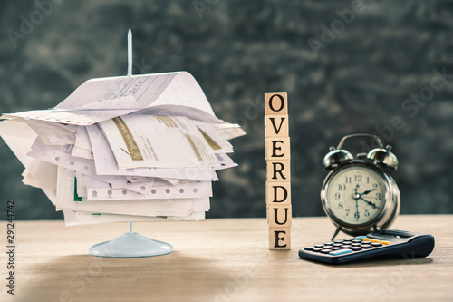 Quadro em tela overdue concept with stack of unpaid bills ,calculator and clock on table