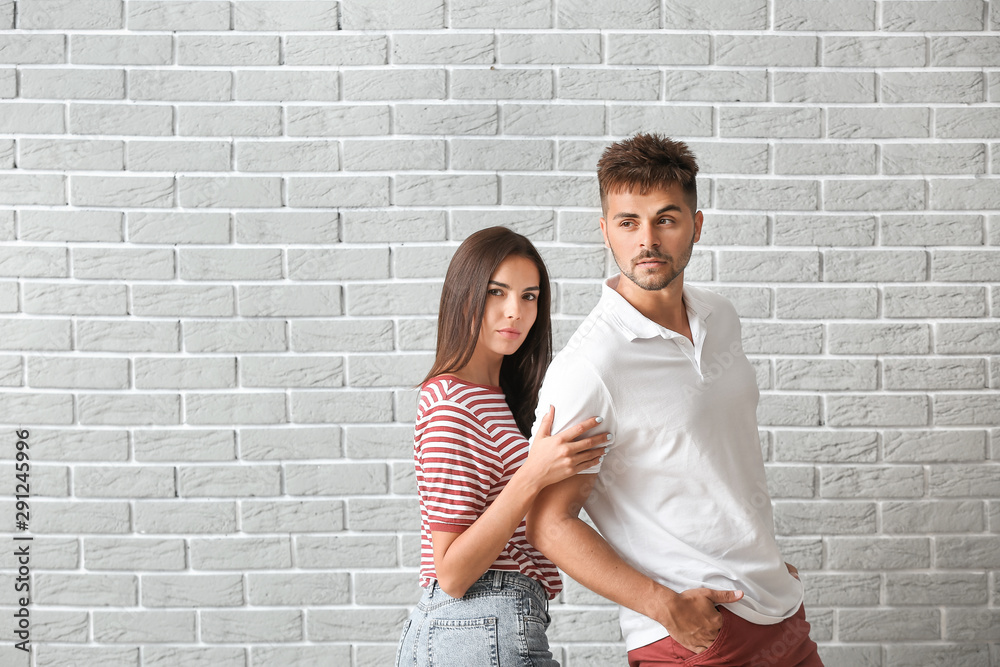Fashionable young couple against brick wall Fashionable young couple against brick wall
