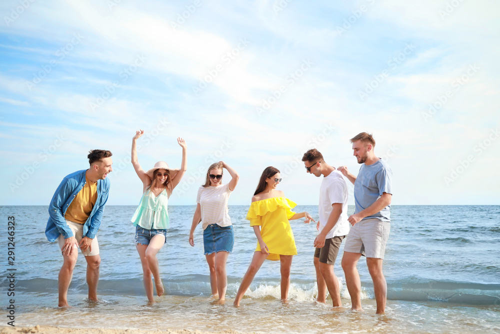 Happy friends on sea beach at resort