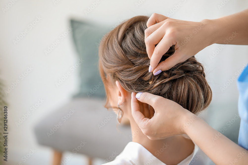 Naklejka premium Professional hairdresser working with young bride at home