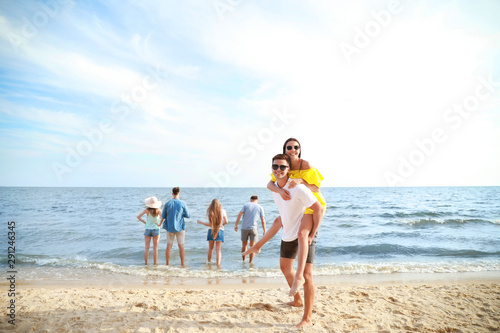 Happy friends on sea beach at resort