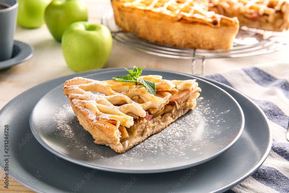 Plate with slice of tasty apple pie on table