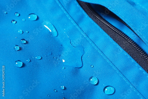 Obraz na plátně Closeup of water drops on bright blue fabric and black zipper with waterproof de