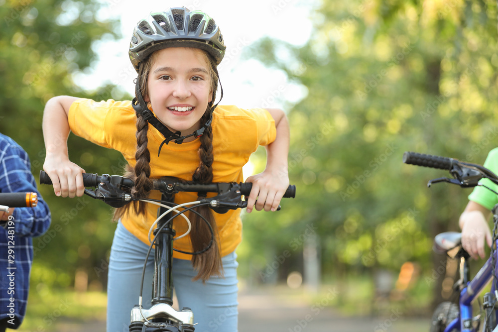 Naklejka premium Cute children riding bicycles outdoors