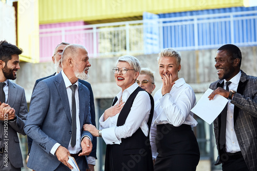 Group of businessmen wear stylish suits in the street laughing