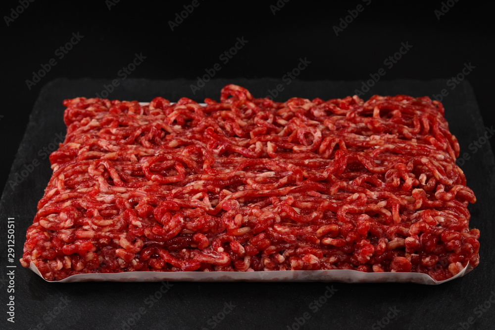 Chopped raw meat on a black background. Chopped raw meat on a black background.