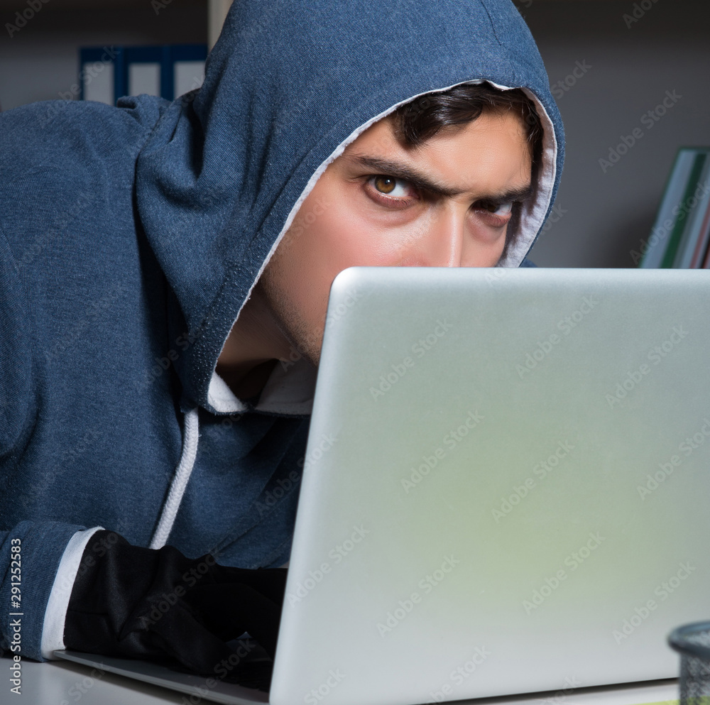 Young hacker hacking into computer at night Young hacker hacking into computer at night