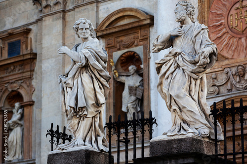 Baroque sculptures of the Apostles on the plinths in front of the Saints Peter and Paul church in Krakow illuminated in the dawn