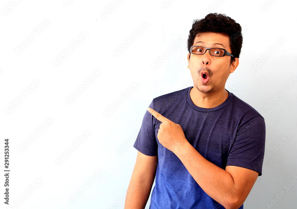 Shock and surprise face of Asian man point on empty space On a white background.. Shock and surprise face of Asian man point on empty space On a white background..