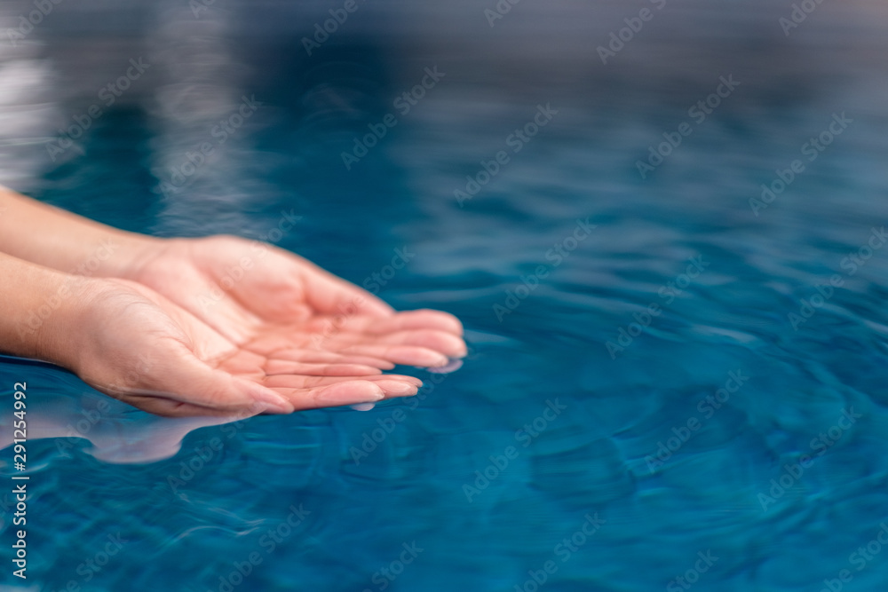 Closeup image of hands scooping clear water
